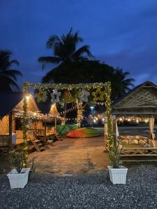 a gazebo with lights on the beach at night at The White House Pakbara in Ban Pak Ba Ra