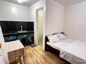 a small bedroom with a bed and a sink at Lugadia Inn- Abels El nido in El Nido