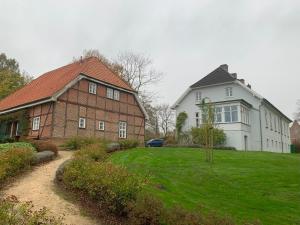 a large brick house next to a white house at FeWo Naturblick mitten im schönen Cuxland Perfekt für Familien mit Hunden in Stinstedt