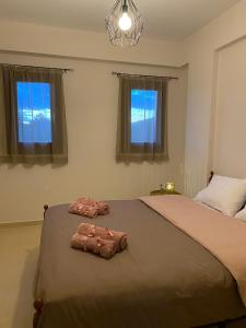 a bedroom with two beds and two windows at Villa Marialena III in Kato Gatzea