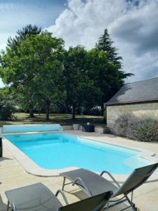 a large swimming pool with chairs next to a house at Au jardin de Florentine in Ingrandes-de-Touraine