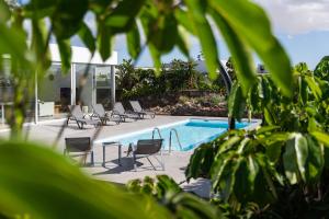 a swimming pool with lounge chairs and a swimming pool at Almara House - Luxury Villa with Heated Pool in La Oliva