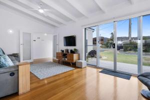 a living room with a couch and a tv at Beachfront Holiday Home Close to Airport in Lauderdale
