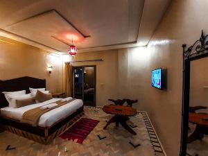 a bedroom with a bed and a tv on the wall at Imsouane WOOD HOUSE in Imsouane