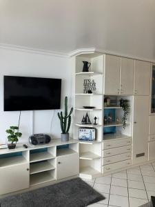 a living room with a large white entertainment center at Meerblick Wolke 7 in Timmendorfer Strand +25 photos