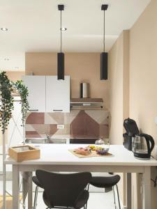 a kitchen with a white table and two chairs at Appartamento Dalì in Brescia