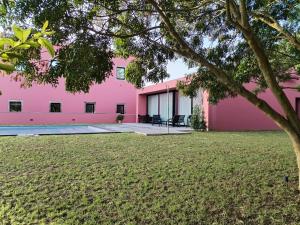 a pink house with a yard at Quinta da Casa Grande in Ponta Delgada
