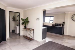 a living room with a sink and a clock on the wall at Tranquil Tides in Yzerfontein