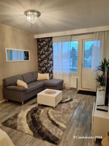Una sala de estar con un sofá y una mesa de café. en Tyylikäs kaksio keskustasta parkkipaikalla,wifi, en Lappeenranta