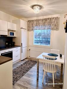 cocina con mesa y ventana en Tyylikäs kaksio keskustasta parkkipaikalla,wifi, en Lappeenranta