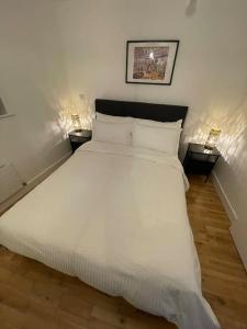 une chambre avec un grand lit blanc avec deux lampes dans l'établissement Fabulous Leeds City Center Urban Loft, à Leeds
