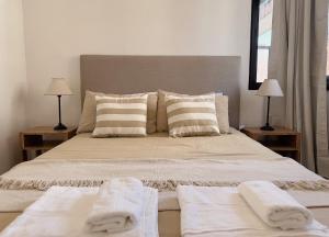 ein Schlafzimmer mit einem großen Bett mit Handtüchern darauf in der Unterkunft Apartamento Obispo Trejo, Nueva Cordoba in Cordoba
