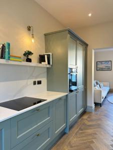 a kitchen with blue cabinets and a counter top at Priory Castle Apartment, Tynemouth in Tynemouth