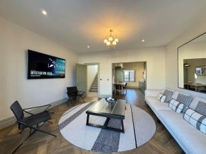 a living room with a white couch and a table at Priory Castle Apartment, Tynemouth in Tynemouth