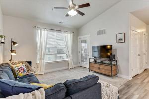 a living room with a couch and a flat screen tv at FrontRunner Lehi Station Fully Equipped Kitchen in Lehi