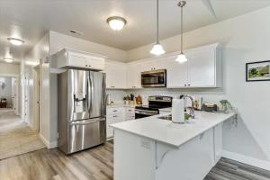 a kitchen with white cabinets and a stainless steel refrigerator at FrontRunner Lehi Station Fully Equipped Kitchen in Lehi +38 photos