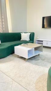 a living room with a green couch and a coffee table at Modest Apt on the Lake in Kampala