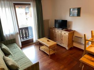 een woonkamer met een bank en een tv bij Sport Hotel Astoria Residence in La Villa