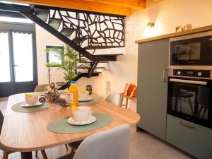 a kitchen with a wooden table with two cups on it at Les Gites d'Andréa- Chez les Fifou in Surba