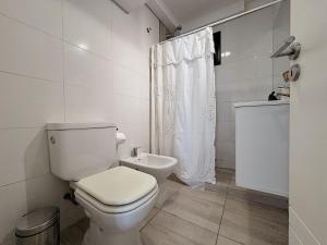 ein weißes Badezimmer mit Toilette und Dusche in der Unterkunft Apartamento Obispo Trejo, Nueva Cordoba in Cordoba + 9 Fotos