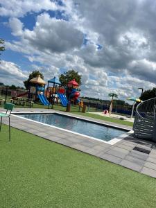 ein Spielplatz mit Pool und Rutsche in der Unterkunft Chalet-Frank in Lathum