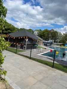 ein Schwimmbad mit Pavillon in einem Park in der Unterkunft Chalet-Frank in Lathum