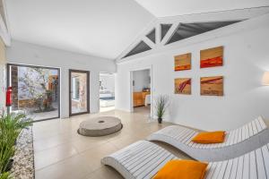 a living room with two white couches and orange pillows at Tons da Terra - Casa de Campo & SPA in São Domingos