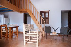 a room with a staircase and chairs and a table at CAN TONI DEN MESTRE in Cala Saona