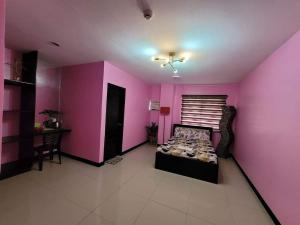 AltavasY&M Hotel Inn ALTAVAS AKLAN的粉红色的客房配有一张床和一张桌子