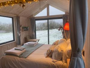 a bed in a room with a large window at Otterly's Retreat in Skibbereen +16 photos