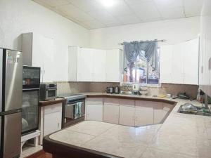 DaanbantayanにあるHuge house with seaviewの白いキャビネットとシンクを備えた広いキッチン