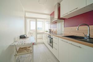 a kitchen with white cabinets and a sink at Appartement familial - proche Paris in Alfortville
