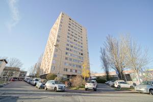 a tall building with cars parked in a parking lot at Appartement familial - proche Paris in Alfortville