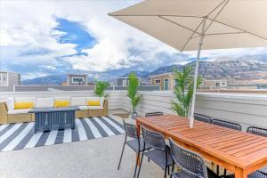 a patio with a table and chairs and an umbrella at Right off i15 Rooftop Patio BBQ Grill in American Fork