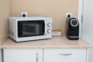 a microwave sitting on top of a kitchen counter at Asterias Boutique Hotel in Pachaina