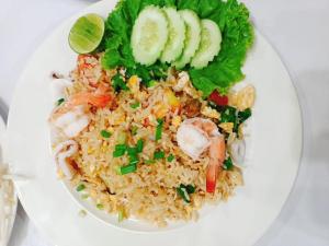 a plate of food with rice and shrimp and vegetables at Moon house Beach Hostel in Haad Rin