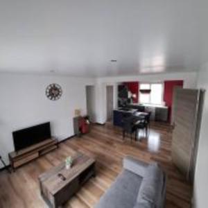 una sala de estar con un sofá y una mesa en T3, 2 chambres avec parking privé, en Aurillac