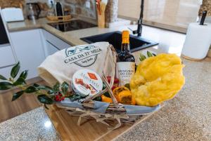 a basket of food and a bottle of wine on a counter at Casa da Ti Mília in Trancoso +41 photos