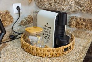 a coffee maker and glasses in a basket on a counter at Casa da Ti Mília in Trancoso