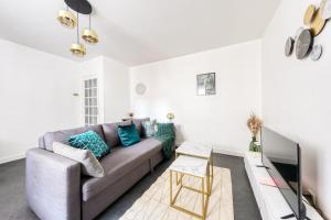 un soggiorno con un divano e una TV di Appartement paisible proche Paris - Métro 11 a Romainville