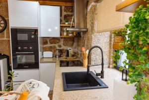 a kitchen with a sink and a counter top at Casa da Ti Mília in Trancoso