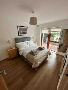 a bedroom with a large bed and a wooden floor at BTown 2 Bed 2 Bath in Ballybrack