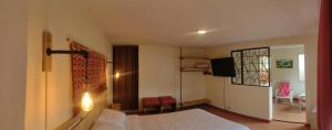 a bedroom with a bed and a television in it at El Jardín cerca Aeropuerto de Pasto, comodidad y descanso in Chachagüí