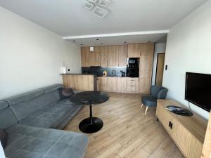 苏瓦乌基Apartament Amelium Darmowy podziemny parking的带沙发和桌子的客厅和厨房
