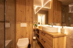 a bathroom with a sink and a toilet and a shower at Osada LoveLaski - balia jacuzzi, sauna i kominek - całoroczne domki premium in Laski +100 photos