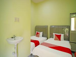 Postel nebo postele na pokoji v ubytování Hotel O Balige City Near Tugu Juara Monang