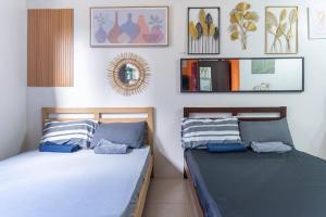 two beds sitting next to each other in a bedroom at Plumera Condo Near Airport Malls & Schools with Elevator in Lapu Lapu City +33 photos