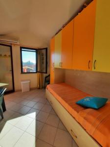 a room with a bed with orange cabinets and a window at Villa Rita in Chia