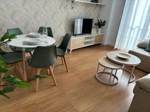 a living room with a table and chairs and a tv at Apartamento turístico Clavero 3 in Plasencia