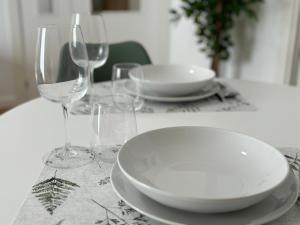 a table with plates and wine glasses on it at Apartamento turístico Clavero 3 in Plasencia +13 photos